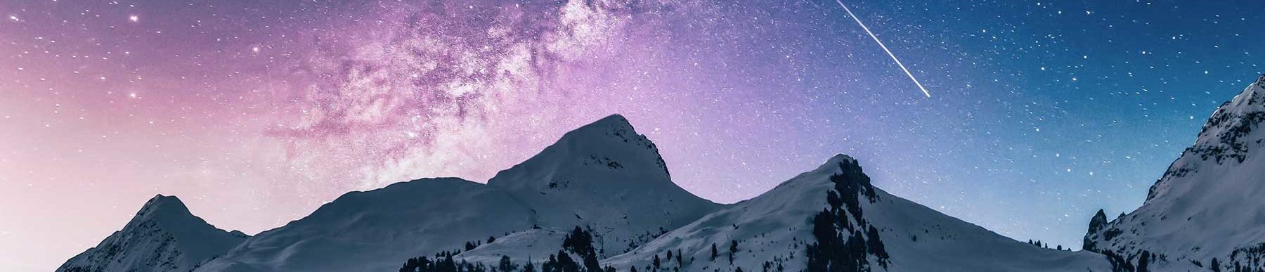 Snow covered mountains in purple sky with a shooting star and the milky way